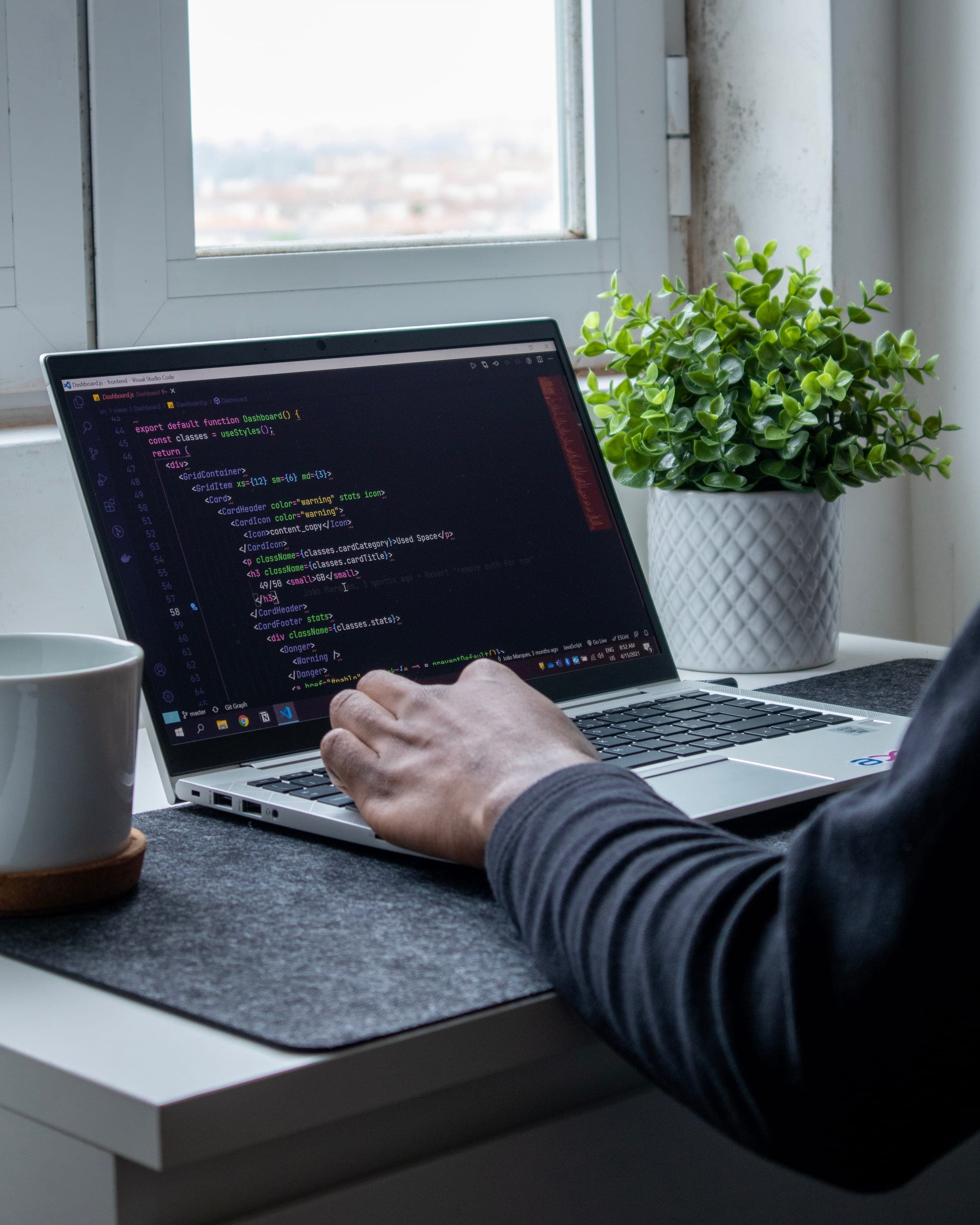 A laptop with source code displayed on the screen – representing software development and programming.